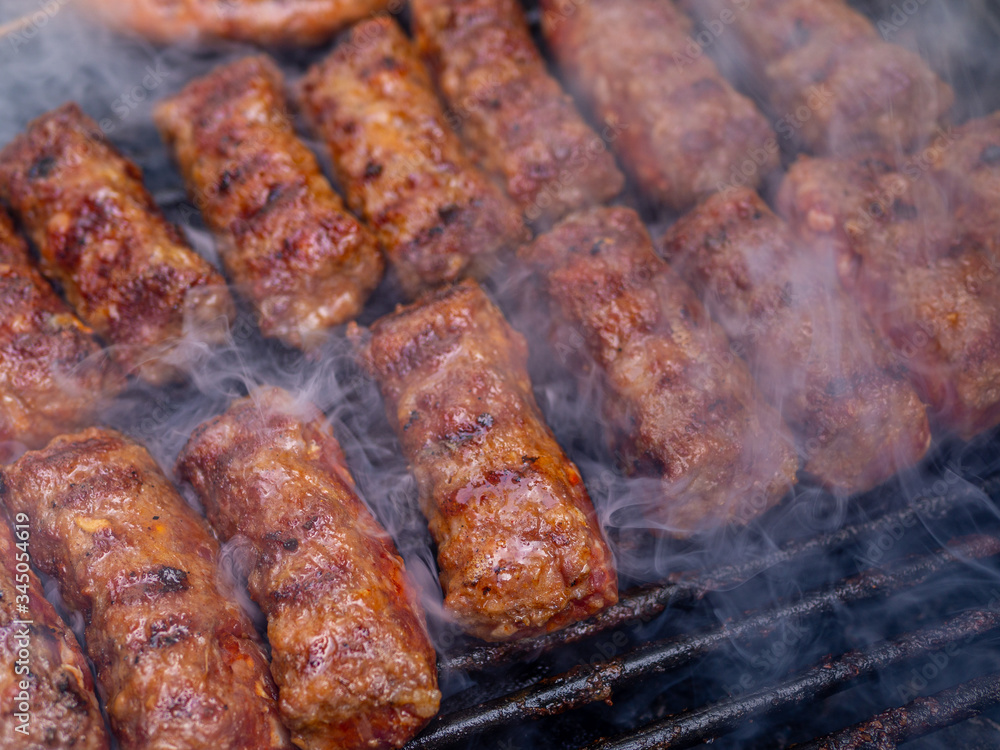 minced meat rolls or mici cooking on barbecue traditional romanain balkan ottoman dish 1st of may labor day celebration 