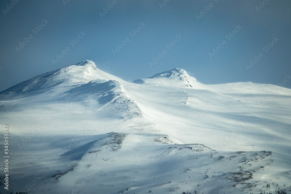 Winter landscape with dramatic snowy mountains.