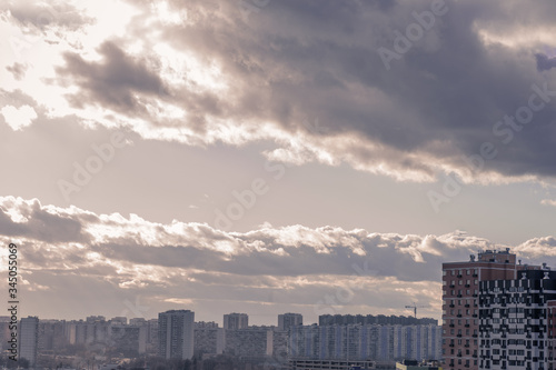 view of the residential quarter of the city at sunset with volume clouds