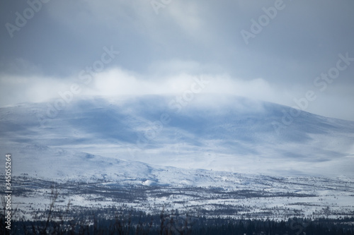 Winter landscape with cloudy snowy mountains. © Forenius