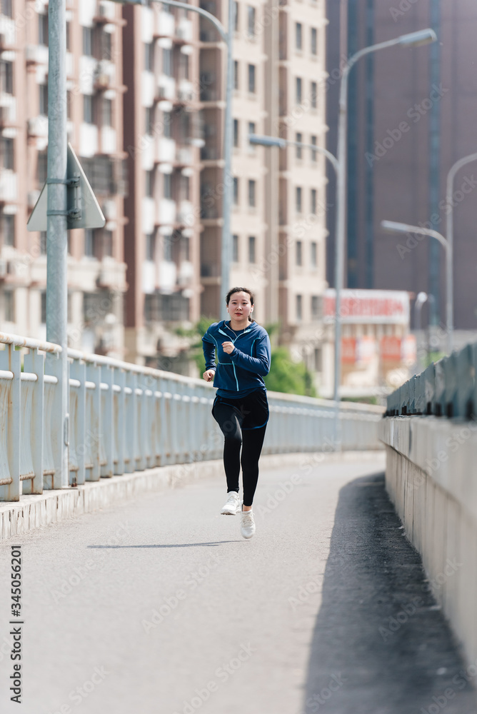 A young Asian Chinese woman is running