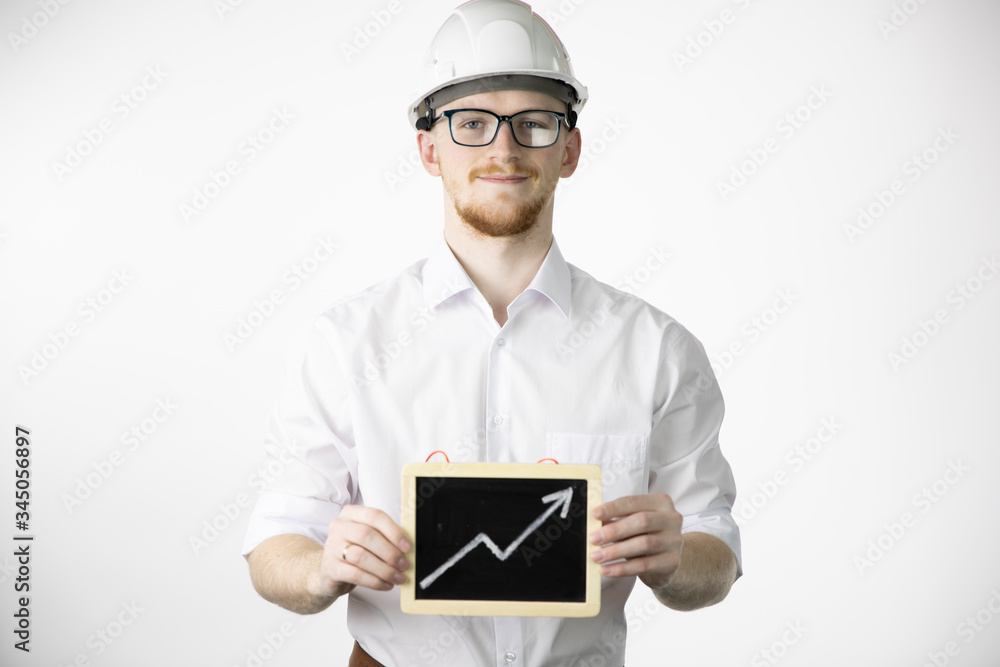 Happy mining engineer holding sign with up arrow rising oil quotes and looks at camera with smile. Oil refinery industry, market strengthening, growth of quotes, sales and supply growth concept Happy mining engineer holding sign with up arrow rising oil quotes and looks at camera with smile. Oil refinery industry, market strengthening, growth of quotes, sales and supply growth concept