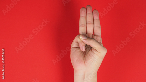 A hand sign of 3 fingers point upward meaning three, third or use in protest.It put on red background