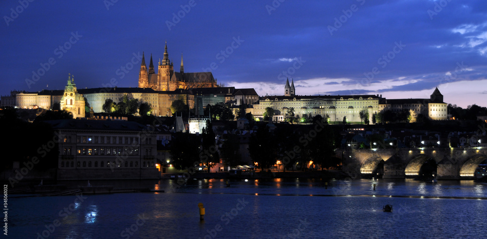 Charles Bridge over the Vltava, historic quarters and St. Vitus Cathedral. Quiet summer evening in Prague.