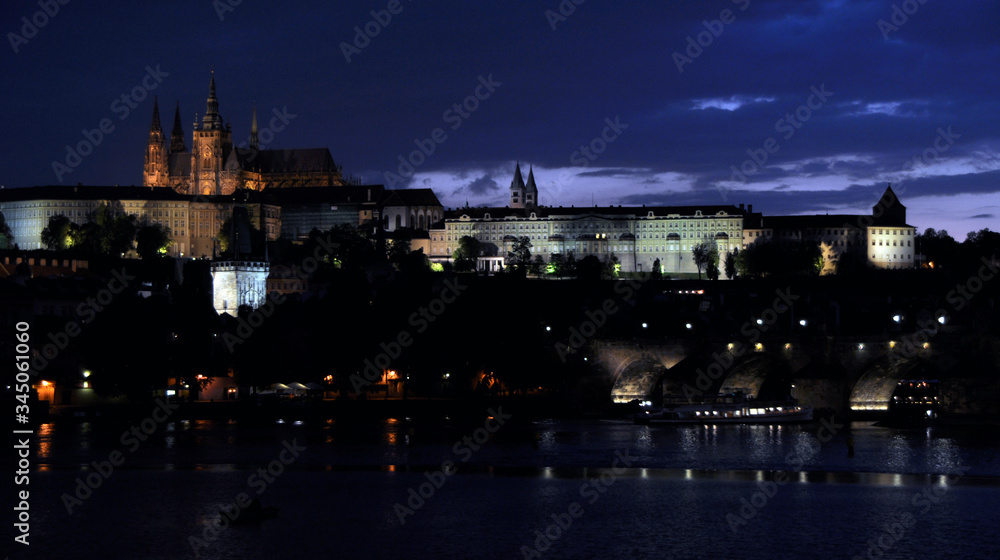 Charles Bridge over the Vltava, historic quarters and St. Vitus Cathedral. Quiet summer evening in Prague.