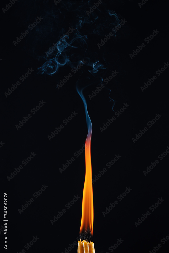 Candles burning with the same big flame on a dark background. Movement of abstract smoke. Candles with merged into one flame. Candles burning with the same big flame on a dark background. Movement of abstract smoke. Candles with merged into one flame.