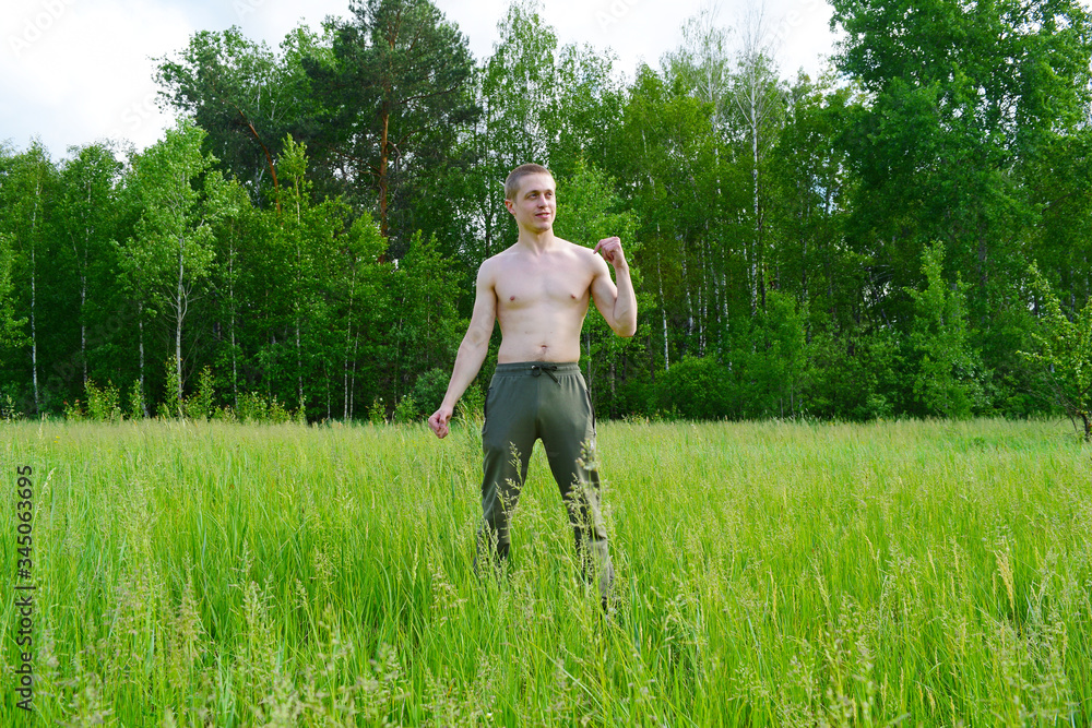 Young sports guy in pants on a green grass Young sports guy in pants on a green grass
