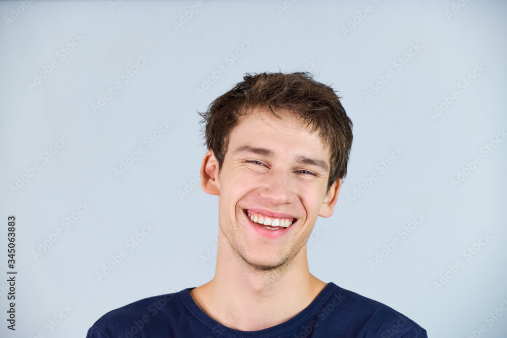 Casually dressed funny young man giving a carefree big smile to the camera. Casually dressed funny young man giving a carefree big smile to the camera.