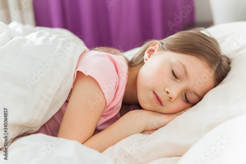 Adorable little girl sleep in the bed close-up