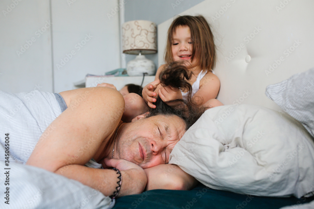 Funny caucasian Child play with sleeping dad Funny caucasian Child play with sleeping dad