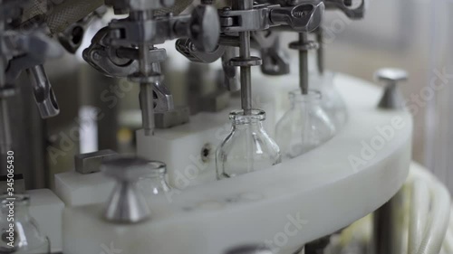glass bottles on a medical solution conveyor at filling station close up selective focus medical industry