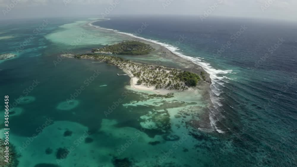 Aerial panning view of island amidst sea against sky - Coco Plum Cay, Belize Aerial panning view of island amidst sea against sky - Coco Plum Cay, Belize