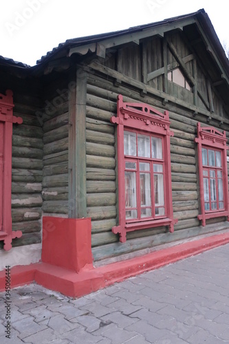 
simple wooden house with red windows