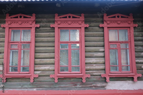 
simple wooden house with red windows