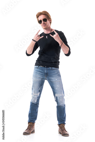 Canvas-taulu Rock and roll musician in black shirt showing hard rock hand sign gesture at camera
