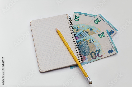 Money is on the table. Notepad for write down expenses. Yellow pencil. Family budget in crisis.