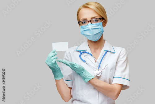 Doctor or woman nurse showing blank empty card with copy space