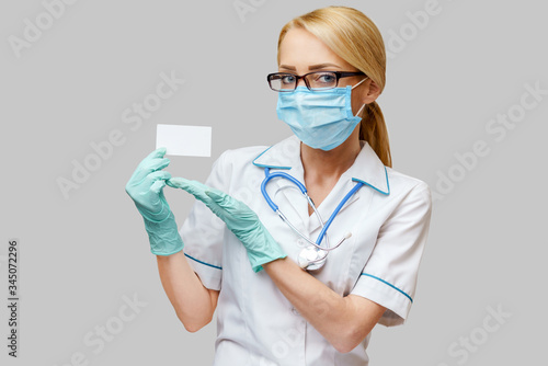 Doctor or woman nurse showing blank empty card with copy space