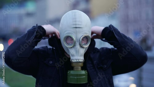 Portrait of man taking off gas mask, showing thumbs up and smiling. Slowmotion. photo