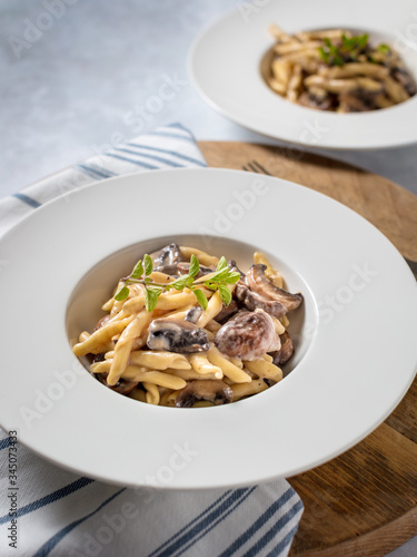 Garlic Mushroom Pasta served in a white bowl on wooden background