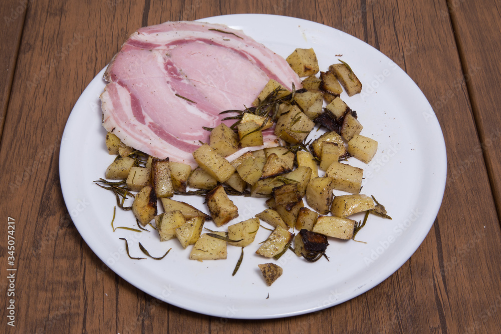 A baked cut pork leg with baked potatoes A baked cut pork leg with baked potatoes