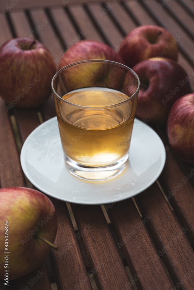 on a table freshly picked apples and a glass with fresh apple juice on a table freshly picked apples and a glass with fresh apple juice