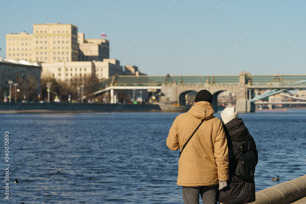 Touristic Moscow. People walking at the Sparrow Hills/ Vorobyovy Gory park in spring time. Back / rear view. Defocused background of cityscape. Coronavirys pandemic lifestyle.