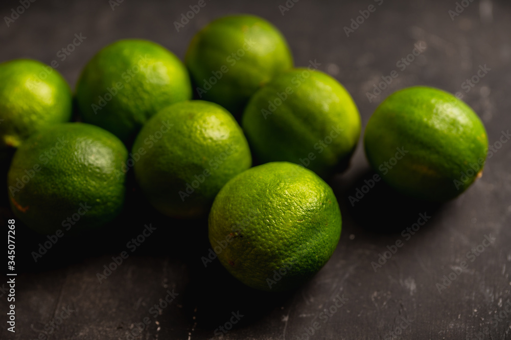Juicy green limes on the rustic background. Selective focus. Shallow depth of field.