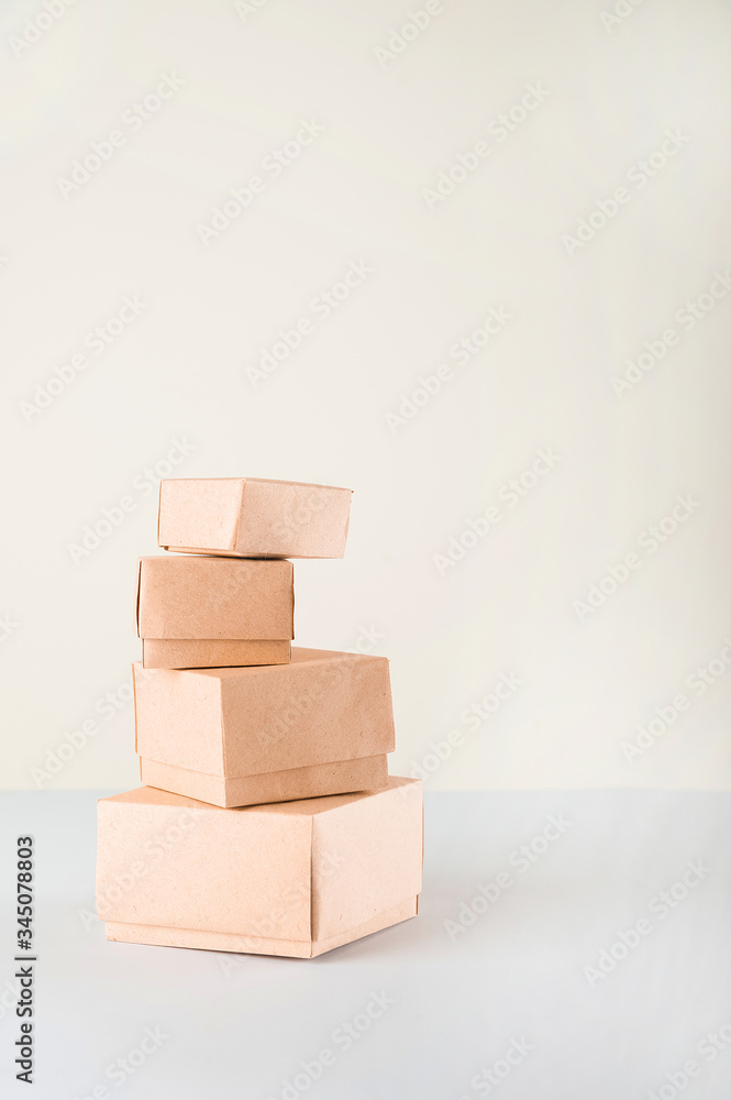 Obraz premium Delivery concept on a white background. Delivery of goods, food online. A lot of boxes on a white background close-up. Miniature trolley and copy space.