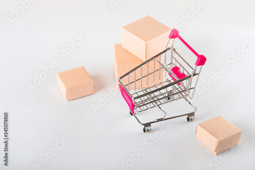 Delivery concept on a white background. Delivery of goods, food online. A lot of boxes on a white background close-up. Miniature trolley and copy space.