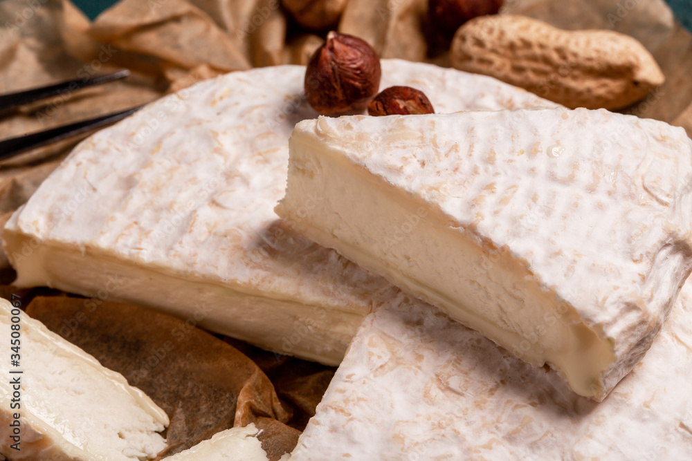 close up Tasty cheese with nuts on linen napkin wooden background copy space cheese knives. National Italian French Camembert or brie cheese close up Tasty cheese with nuts on linen napkin wooden background copy space cheese knives. National Italian French Camembert or brie cheese