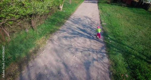 little girl riding scooter on the road in the countryside