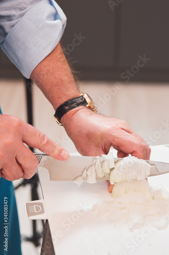 The chef cuts an onion with a knife.