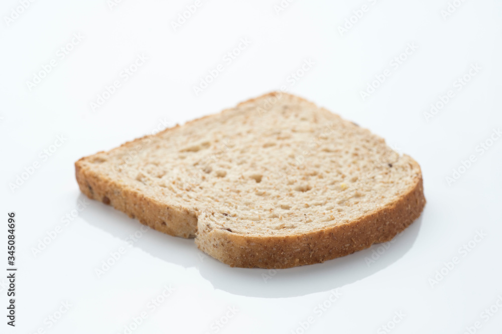 slice of sliced bread with cereals and seeds, on a white surface with reflection slice of sliced bread with cereals and seeds, on a white surface with reflection