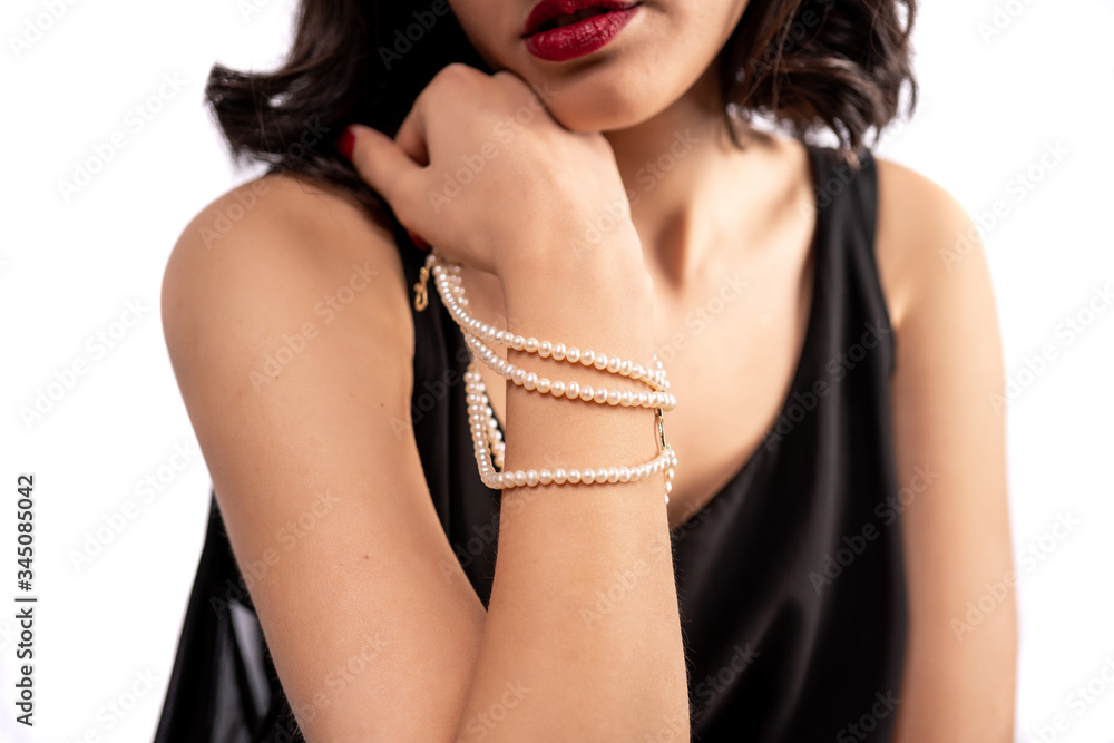 woman wearing pearl diamond wristband on white background
