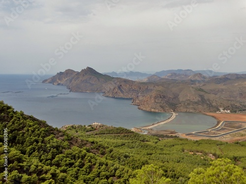 Panorama casi lunar con paisaje de playa de arena rojiza y paraje desértico con acantilados en la costa del Mar Mediterráneo dentro del Parque Regional de Calblanque en Murcia photo