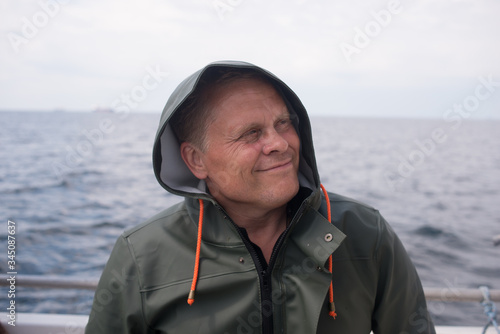 Portrait of a fisherman in a rain jacket on a boat