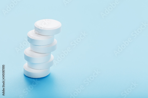 Tower of Medicinal tablets on a blue background, isolated.