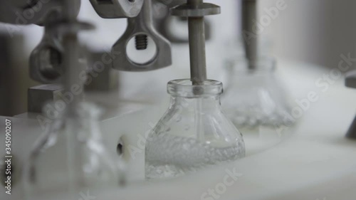 glass bottles on a medical solution conveyor at filling station close up selective focus medical industry