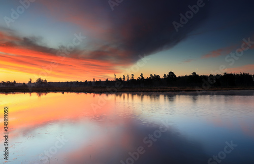 dramatic sunrise over bif forest lake © Olha Rohulya