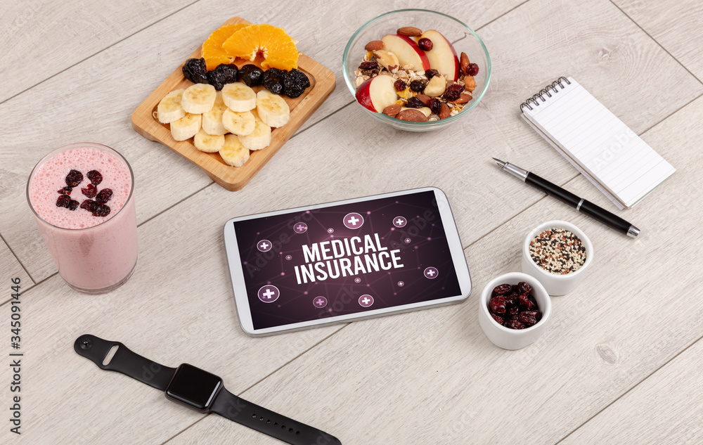 MEDICAL INSURANCE concept in tablet pc with healthy food around, top view MEDICAL INSURANCE concept in tablet pc with healthy food around, top view