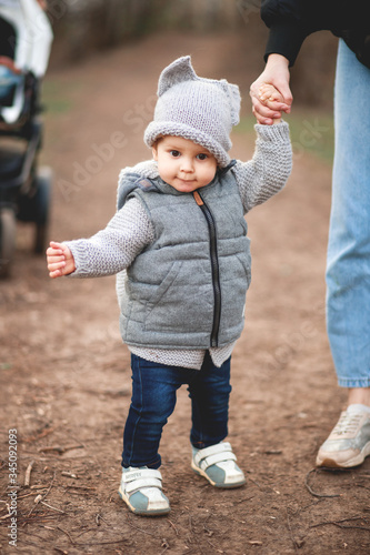 A young mother and her cute little son are walking in the Park