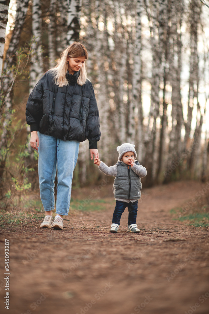 A young mother and her cute little son are walking in the Park
