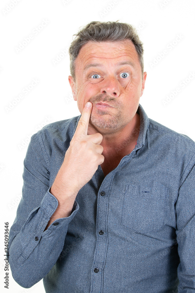 skeptical middle aged man making a face finger on face twisting his mouth skeptical middle aged man making a face finger on face twisting his mouth