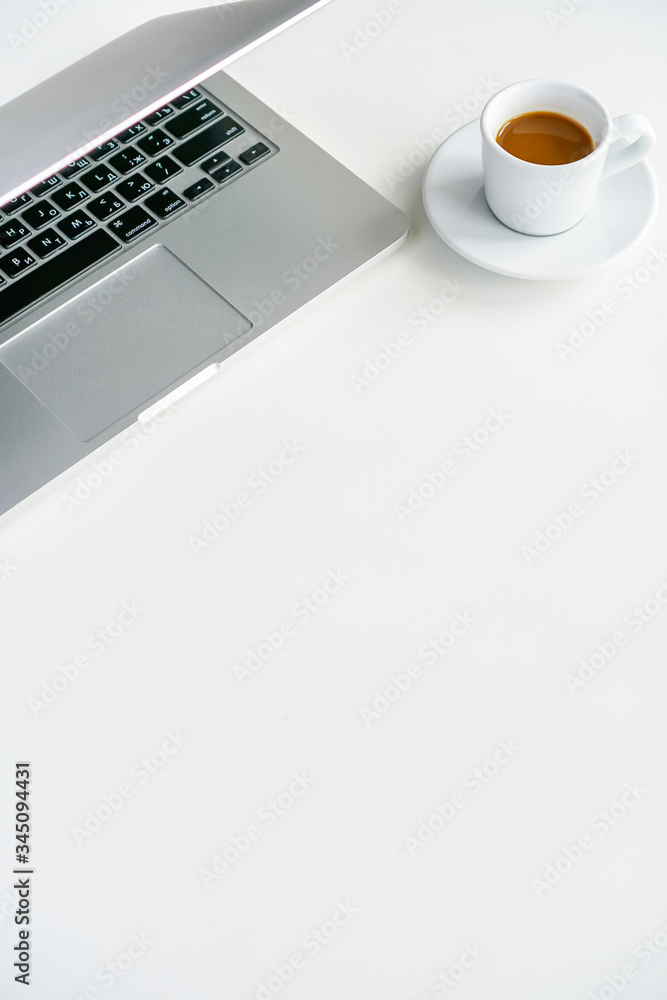 coffee mug and gray laptop on the table on a white background coffee mug and gray laptop on the table on a white background