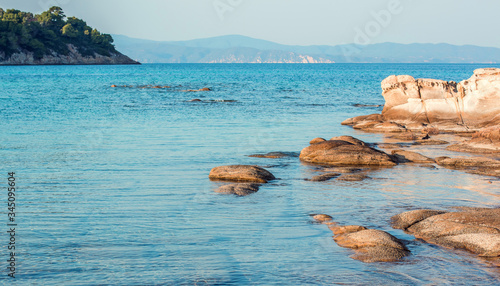 peaceful rocky beach shore line of Mediterranean sea bay shore scenic view in summer day time in July month with background horizon line