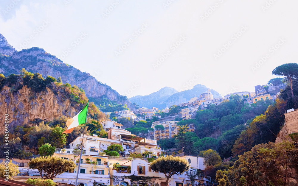 Citiscape with Italian flag and houses at Positano town reflex