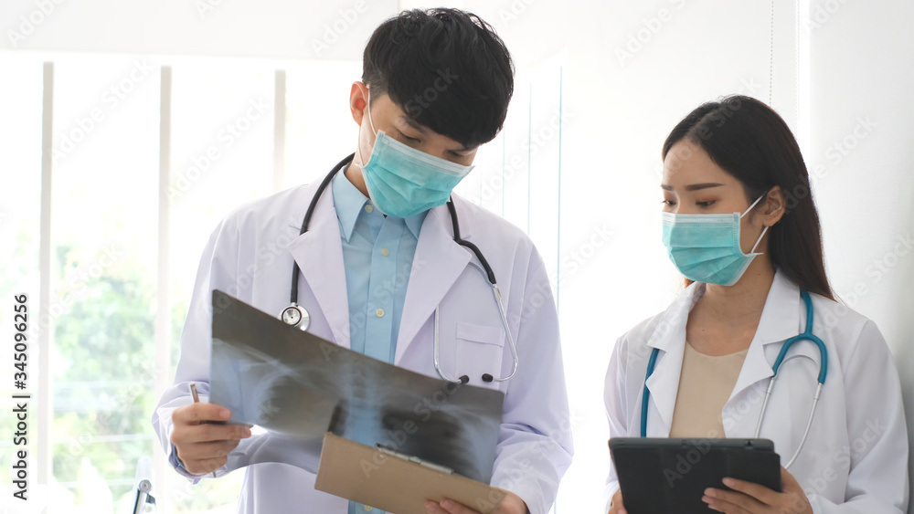 Doctor and nurse discussing the diagnosis of a patient for the future advice for his treatment during walking in a hospital ward. Concept of medicine.Busy Doctors Talk, Using Tablet Computer Doctor and nurse discussing the diagnosis of a patient for the future advice for his treatment during walking in a hospital ward. Concept of medicine.Busy Doctors Talk, Using Tablet Computer