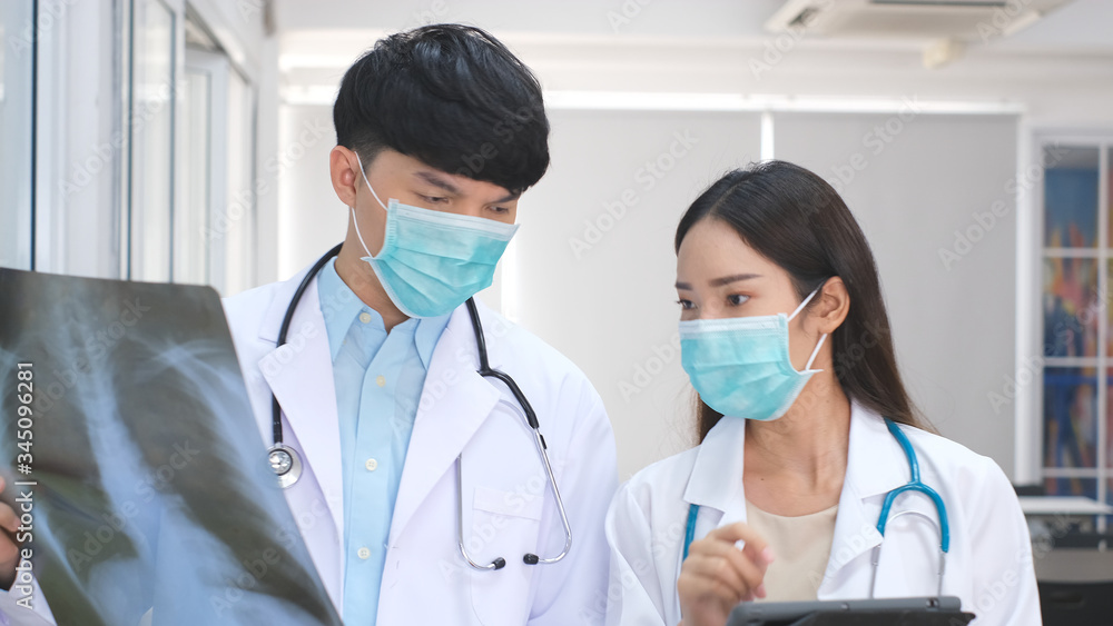 Doctor and nurse discussing the diagnosis of a patient for the future advice for his treatment during walking in a hospital ward. Concept of medicine.Busy Doctors Talk, Using Tablet Computer Doctor and nurse discussing the diagnosis of a patient for the future advice for his treatment during walking in a hospital ward. Concept of medicine.Busy Doctors Talk, Using Tablet Computer
