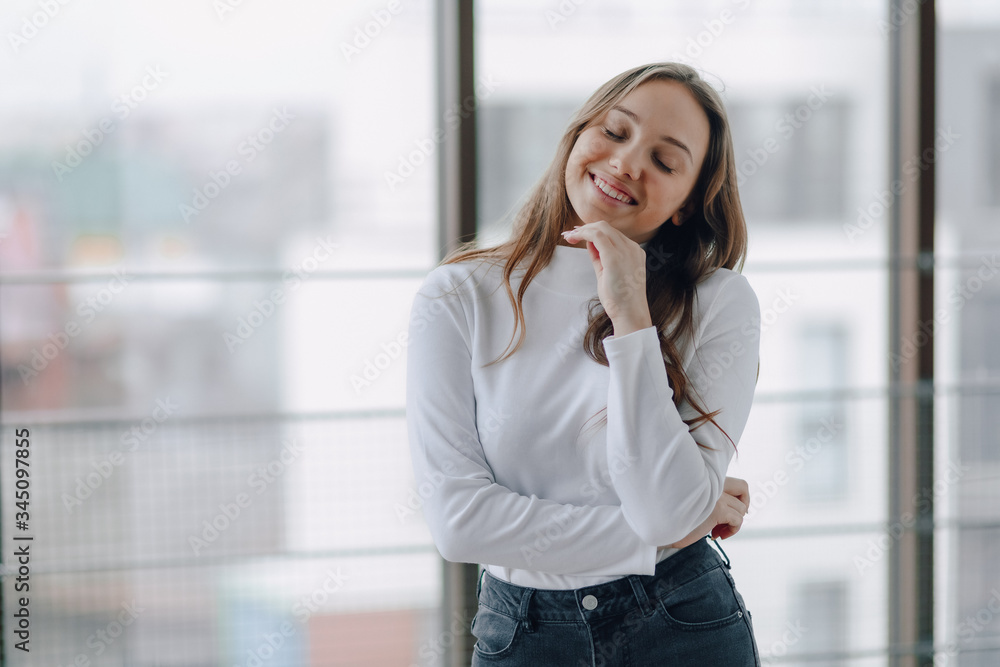 attractive girl on the background of the window shows different emotions and mood. girl on a light background indoors. attractive girl on the background of the window shows different emotions and mood. girl on a light background indoors.